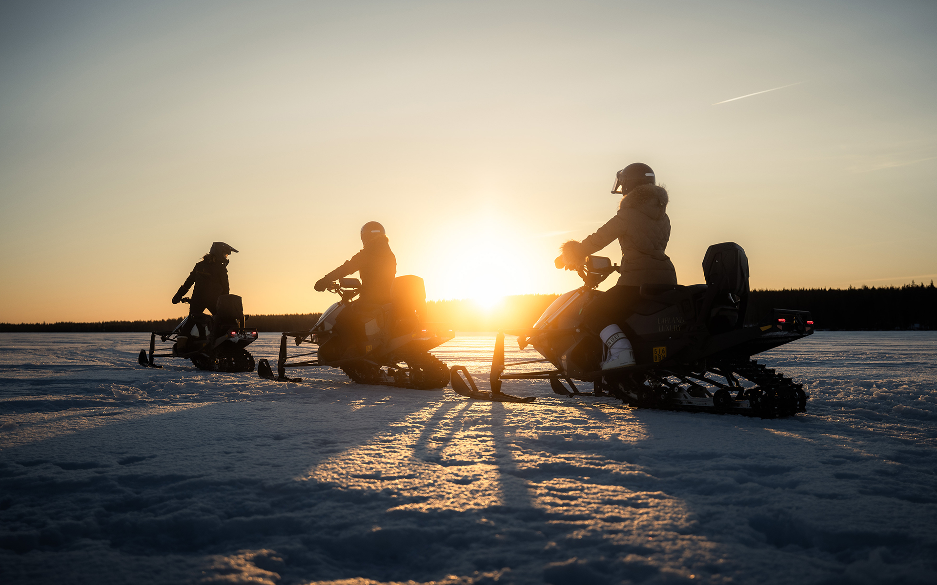 Private snowmobiling tour on the frozen lake. Lapland Luxury.